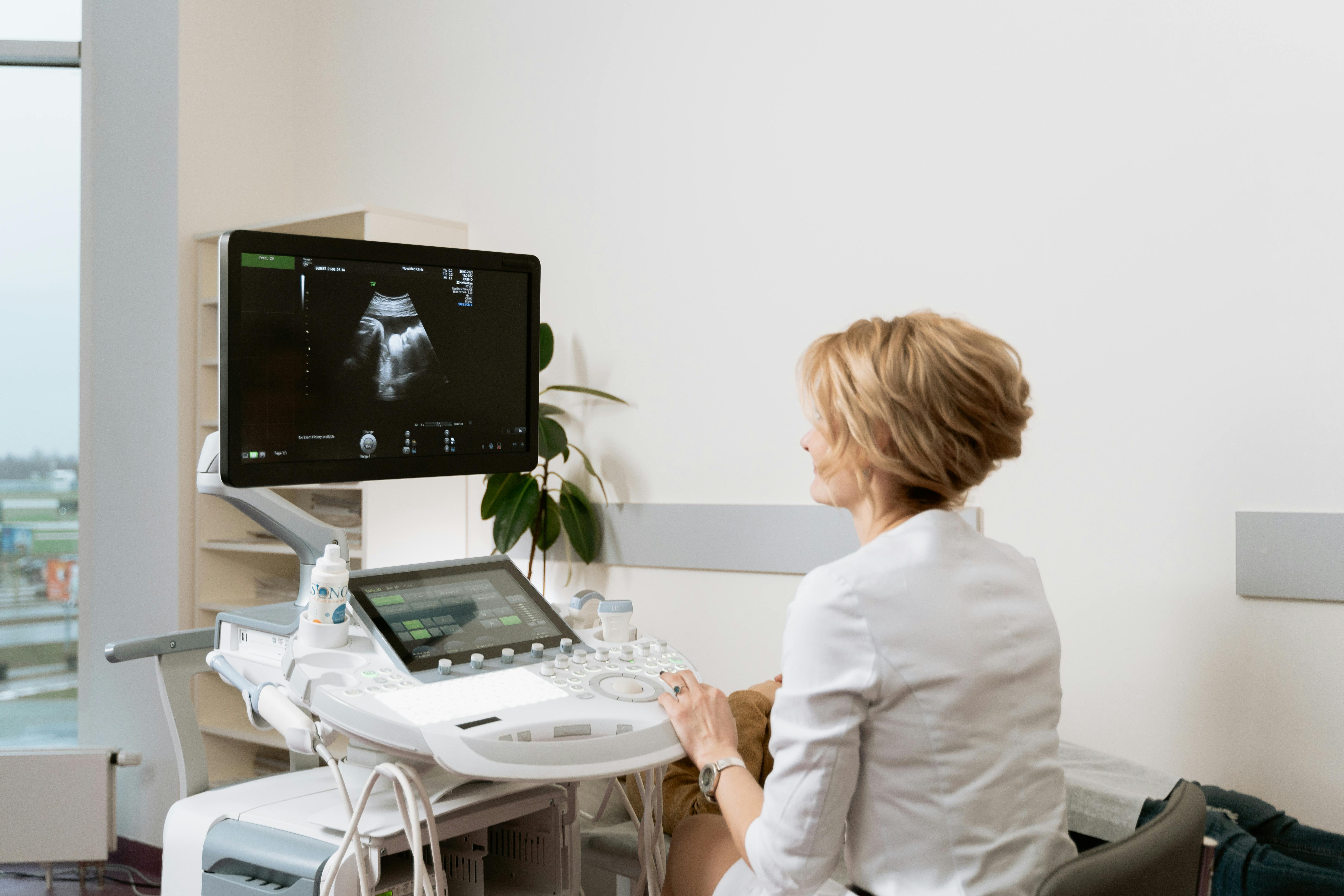 Sonographer performing an ultrasound examination in a calm and professional imaging room.